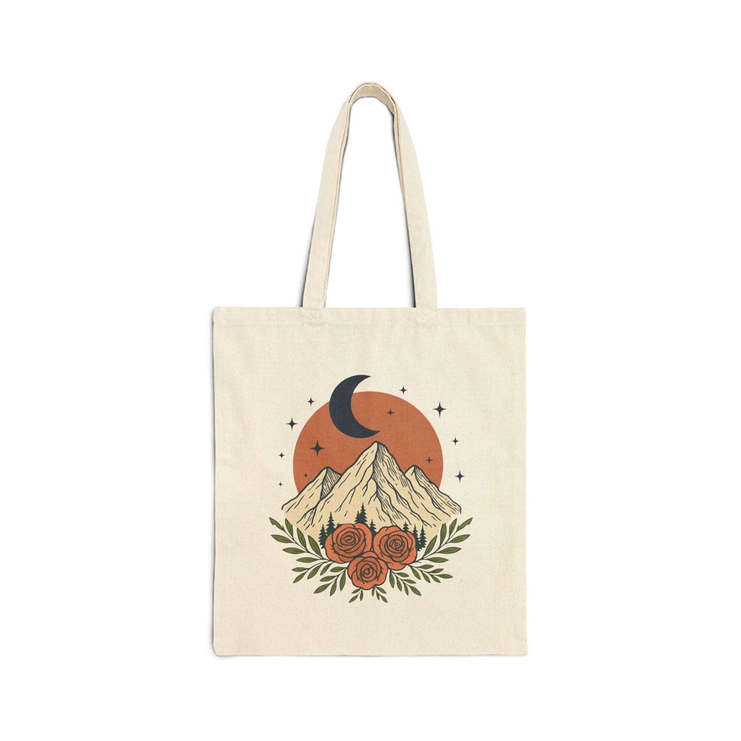Flat-lay of canvas tote bag featuring rustic mountain, crescent moon, and floral rose artwork. Sustainable and stylish shopping tote.