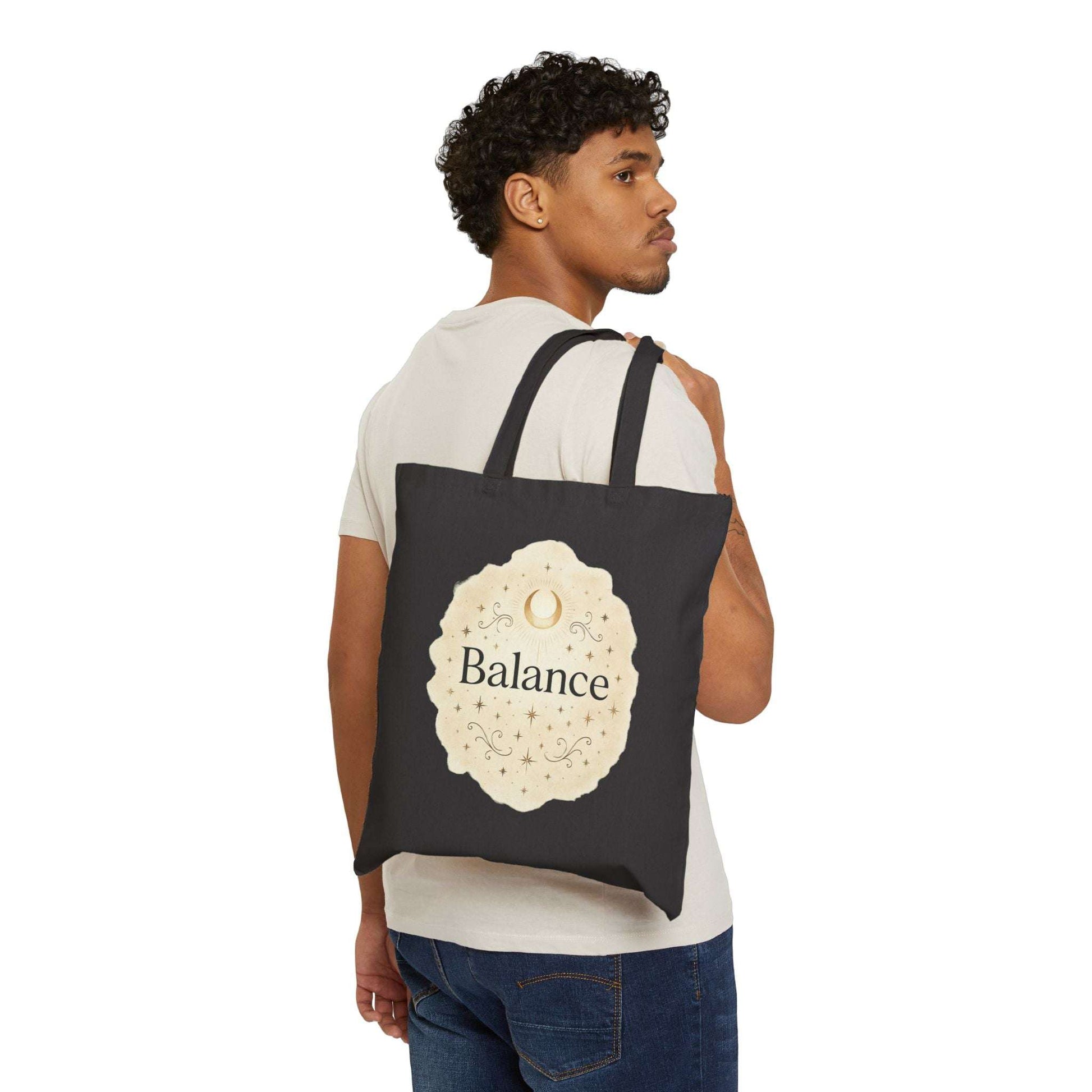 Man carrying a black tote bag with 'Balance' design on a white background