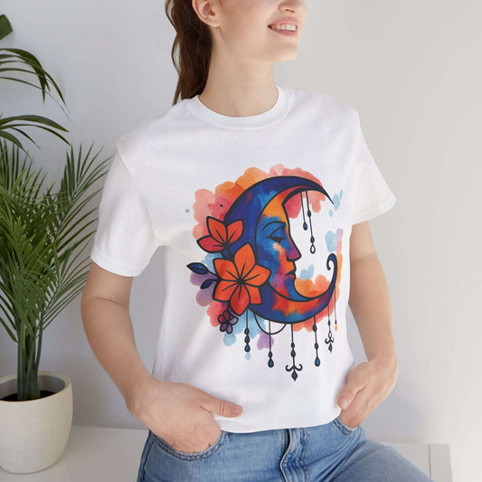 White Floral Moonface Goddess Tee featuring a colorful boho crescent moon with floral accents and charms, ideal for spiritual and festival wear.