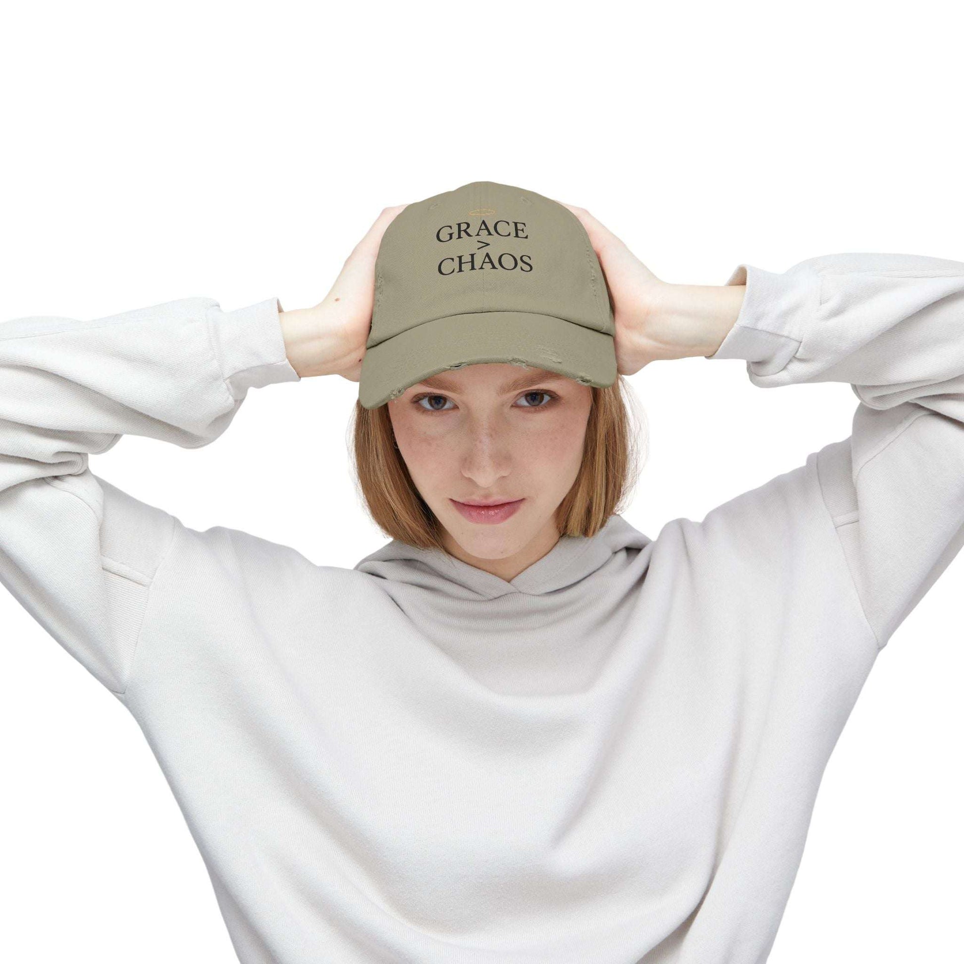 Woman wearing Grace > Chaos Embroidered Distressed Cap in khaki, inspirational baseball hat with minimalist message for casual outfits.