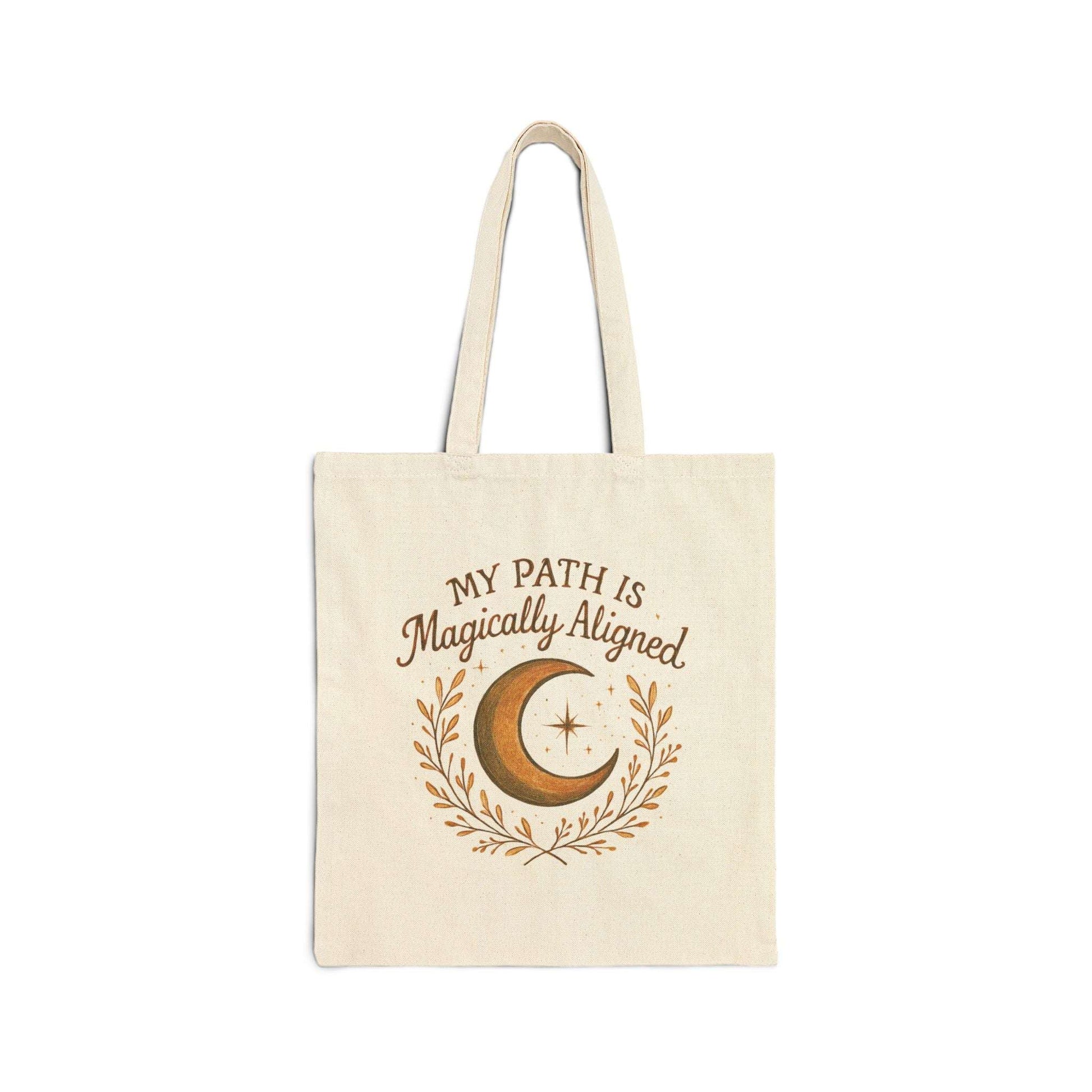 Flat-lay of Boho Moon Canvas Tote featuring crescent moon and stars design with 'My Path Is Magically Aligned' text. Eco-friendly and perfect for everyday use.