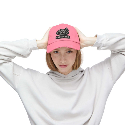 Pink Protected Eye Distressed Dad Hat with embroidered eye graphic, worn by woman in white hoodie. Unisex streetwear baseball cap.