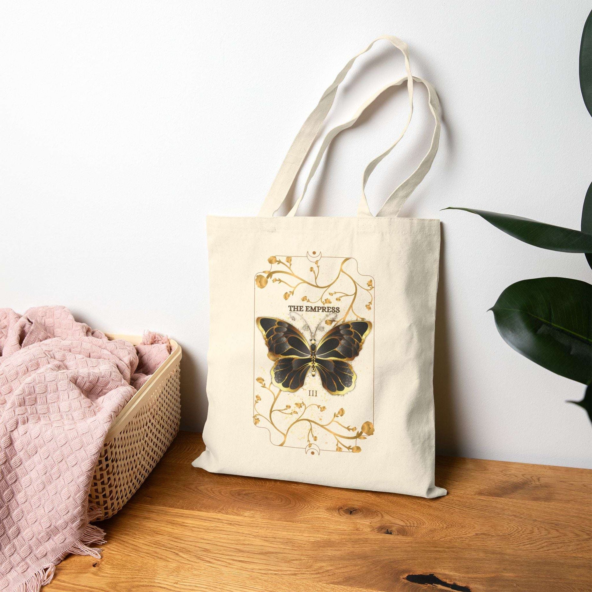 Butterfly Botanical Tote Bag with mystical tarot card design featuring a black butterfly and gold floral accents, perfect for eco-conscious nature lovers.