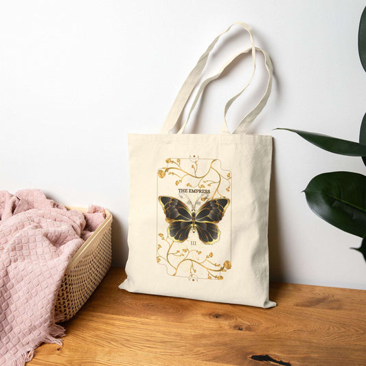 Butterfly Botanical Tote Bag with mystical tarot card design featuring a black butterfly and gold floral accents, perfect for eco-conscious nature lovers.