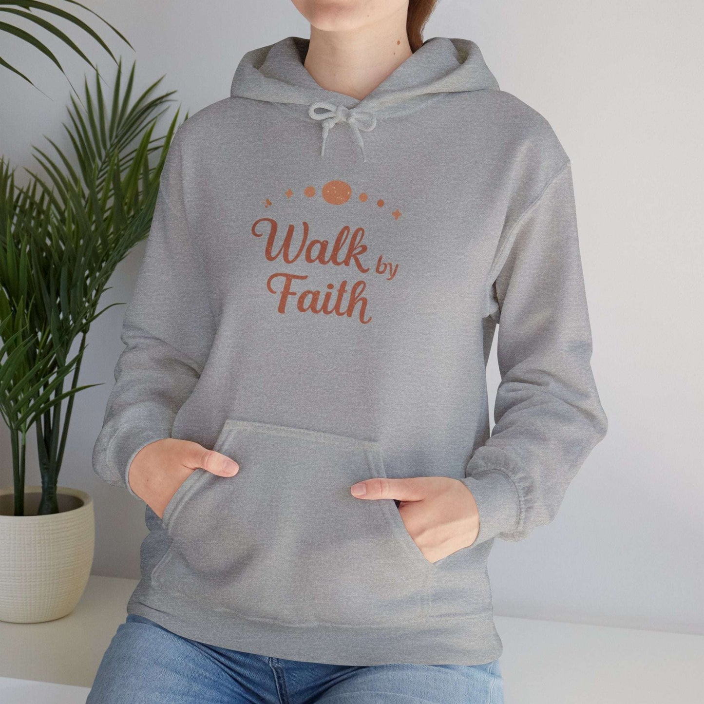 Faithful Walk Hoodie in heather gray with 'Walk by Faith' Christian design, worn by woman in casual indoor setting.