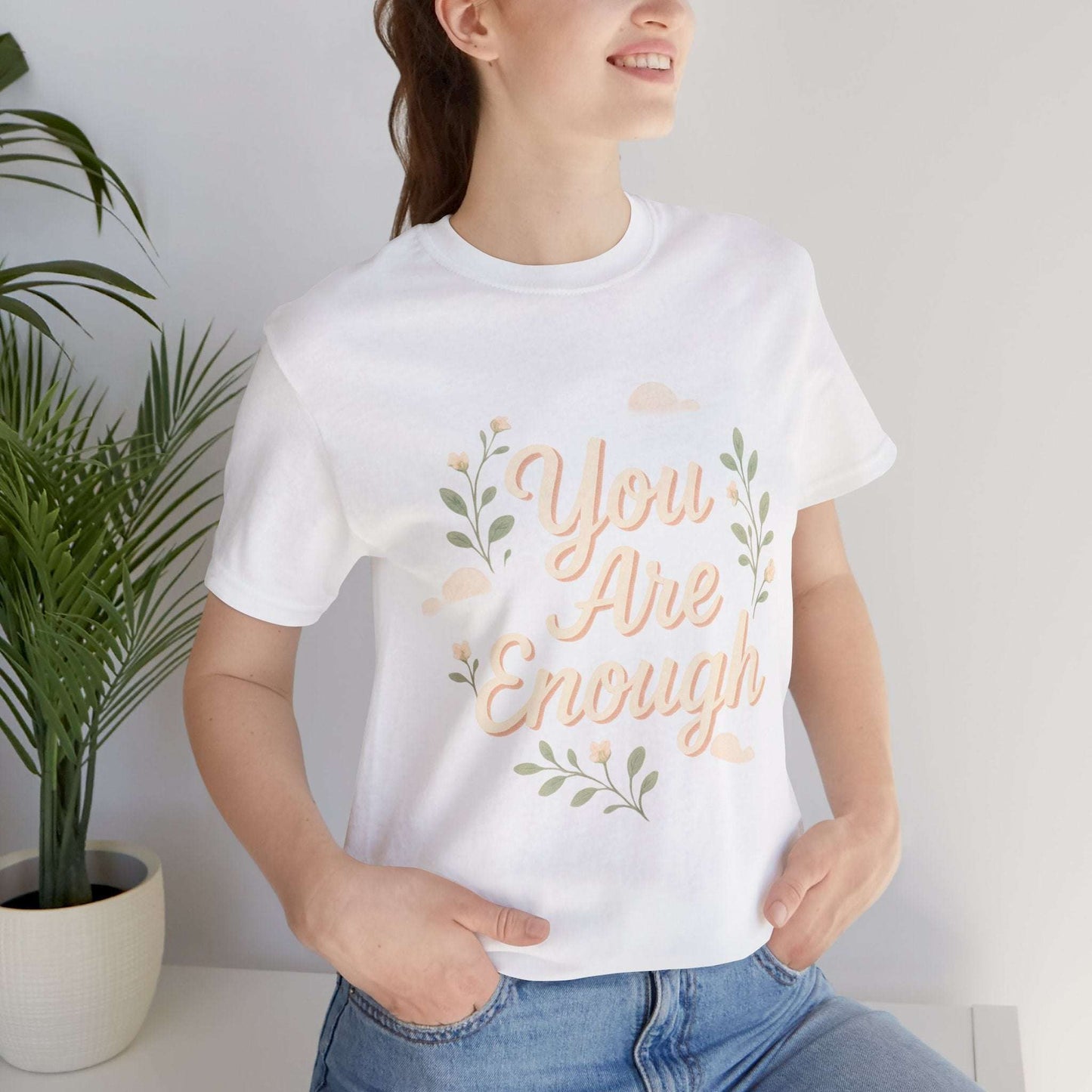 White Floral Tee You Are Enough Unisex Jersey worn by model, showcasing soft cotton fabric and uplifting floral message.