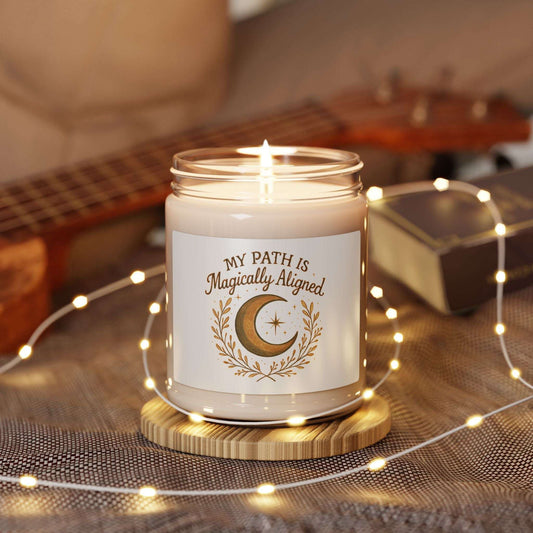 Magically Aligned 9oz Soy Candle — Moon & Stars Scented Jar lit on a wooden coaster with fairy lights, ideal for cozy bedroom ambiance and spiritual rituals.
