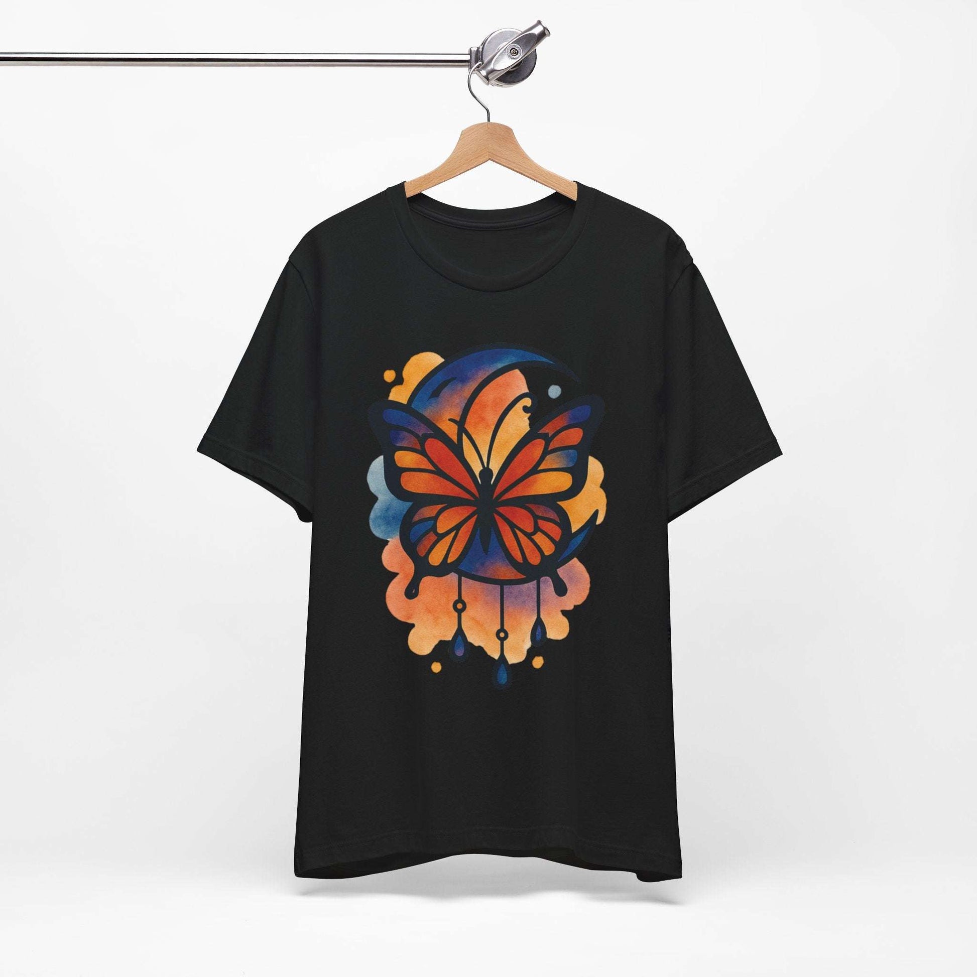 Black t-shirt with a colorful butterfly design on a hanger against a white background