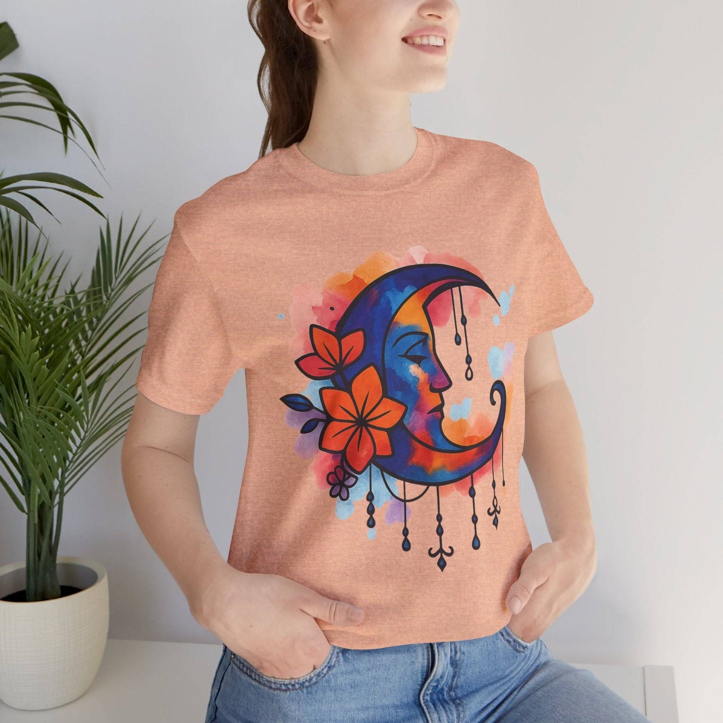 Heather peach Floral Moonface Goddess Tee with vibrant crescent moon and floral art, a cozy boho top for dreamy and spiritual style lovers.